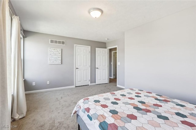 bedroom with light colored carpet, visible vents, and baseboards