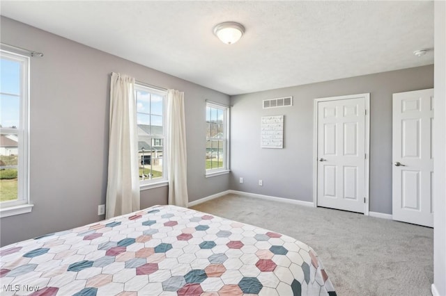 carpeted bedroom with visible vents and baseboards