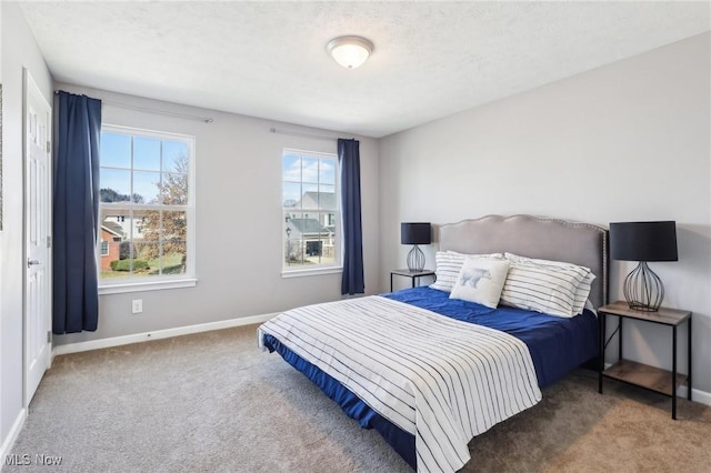 bedroom featuring carpet flooring, a textured ceiling, and baseboards