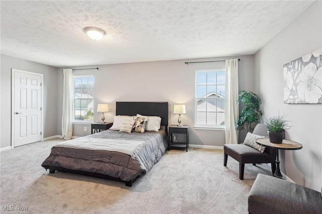 carpeted bedroom featuring baseboards and a textured ceiling