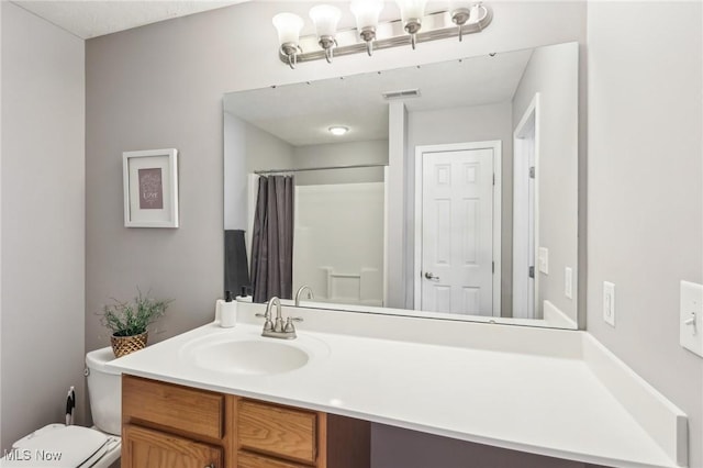 bathroom featuring visible vents, toilet, vanity, and a shower with shower curtain