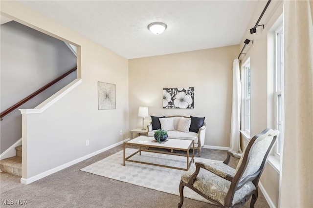 living area with stairs, carpet flooring, and baseboards