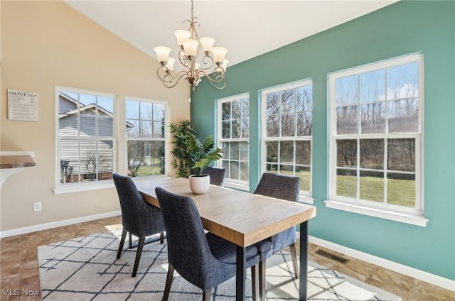 dining space featuring a chandelier, visible vents, lofted ceiling, and baseboards