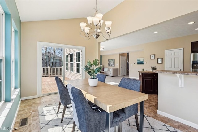 dining room with visible vents, baseboards, vaulted ceiling, light tile patterned floors, and a notable chandelier