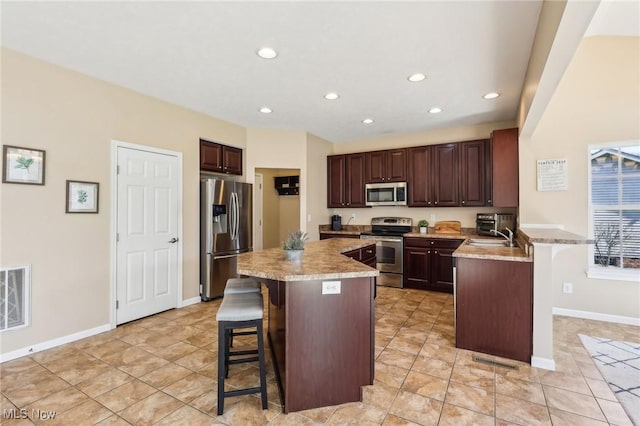 kitchen featuring visible vents, recessed lighting, stainless steel appliances, a kitchen bar, and a center island