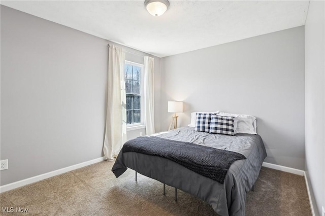 bedroom with baseboards and carpet