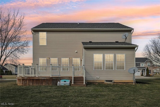 rear view of house featuring a lawn and a wooden deck