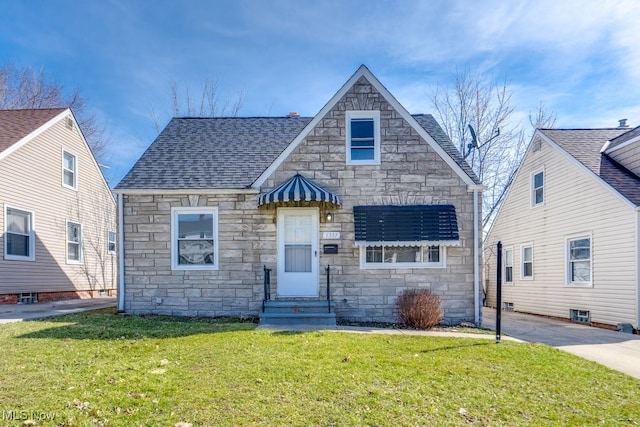 view of front of house featuring stone siding, entry steps, a shingled roof, and a front lawn