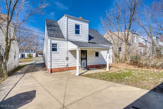 view of front of house with crawl space, driveway, and a shingled roof