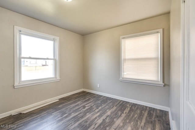 empty room with baseboards and dark wood-style flooring