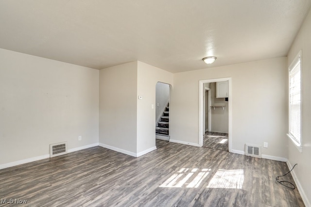 spare room with visible vents, plenty of natural light, and wood finished floors