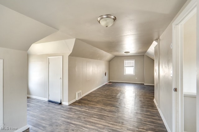 additional living space featuring visible vents, baseboards, wood finished floors, and vaulted ceiling