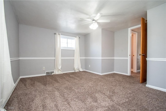 spare room with baseboards, visible vents, carpet floors, and ceiling fan