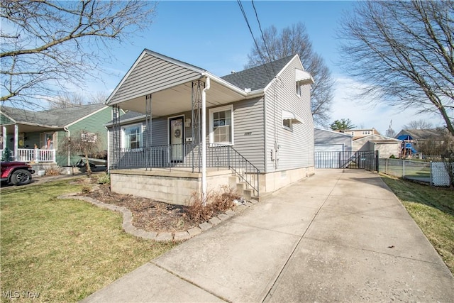 bungalow with a front lawn, fence, covered porch, and a shingled roof