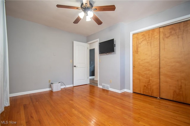 unfurnished bedroom with wood finished floors, visible vents, and baseboards