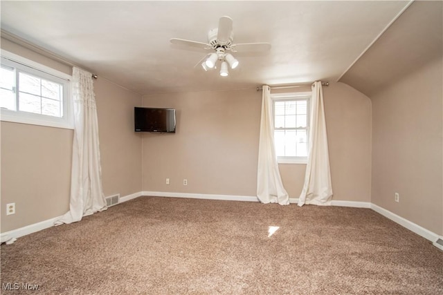 spare room with visible vents, a ceiling fan, baseboards, carpet, and lofted ceiling