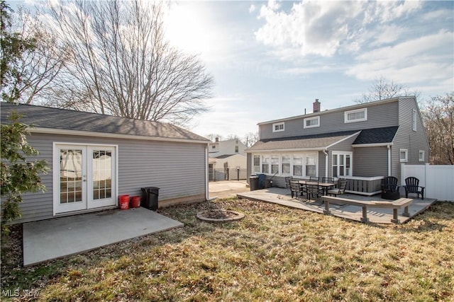 rear view of house with fence, french doors, a yard, a deck, and a patio