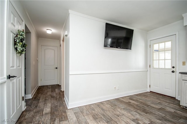 foyer with ornamental molding, baseboards, and wood finished floors