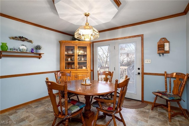 dining area featuring stone finish flooring, baseboards, and ornamental molding