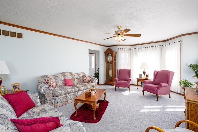 carpeted living area with visible vents, a textured ceiling, and ornamental molding