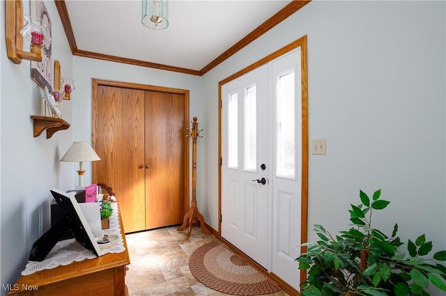 entrance foyer featuring stone finish flooring, baseboards, and crown molding