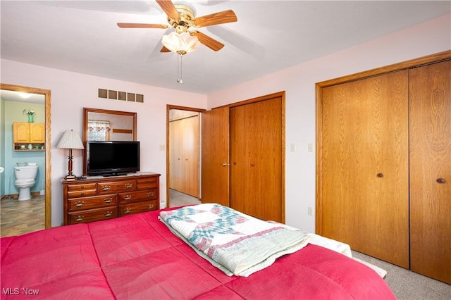 bedroom with visible vents, connected bathroom, two closets, and ceiling fan