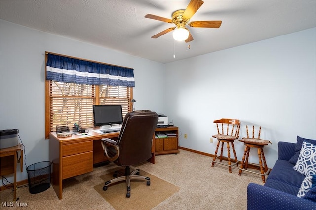 office area with light colored carpet, a textured ceiling, baseboards, and a ceiling fan