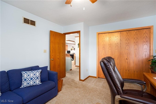 office area featuring visible vents, light carpet, a ceiling fan, a textured ceiling, and baseboards