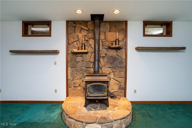 unfurnished living room with recessed lighting, a wood stove, baseboards, and carpet floors