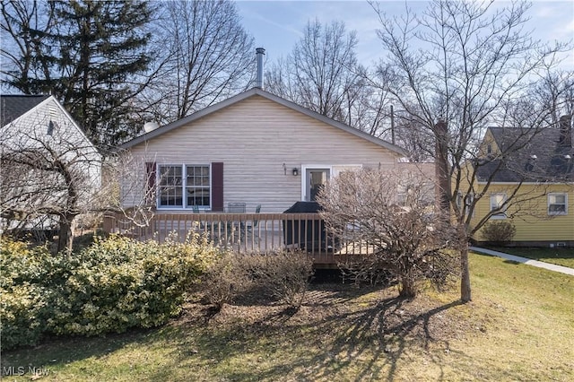 back of property with a lawn and a wooden deck