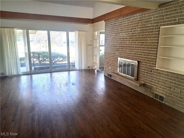 unfurnished living room with dark wood finished floors, visible vents, a brick fireplace, and beam ceiling