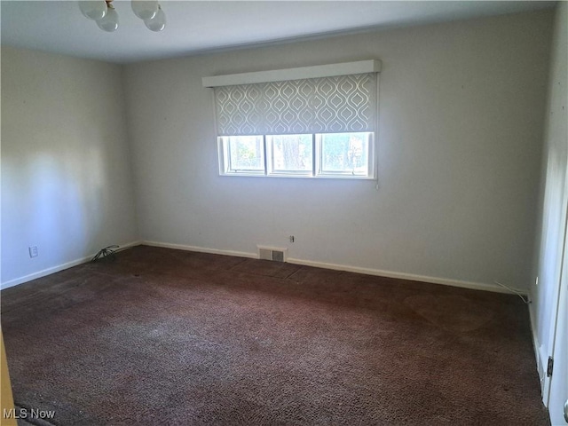 carpeted empty room with visible vents and baseboards