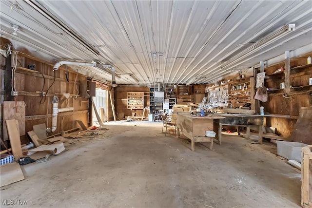 misc room featuring a garage, a workshop area, and concrete floors