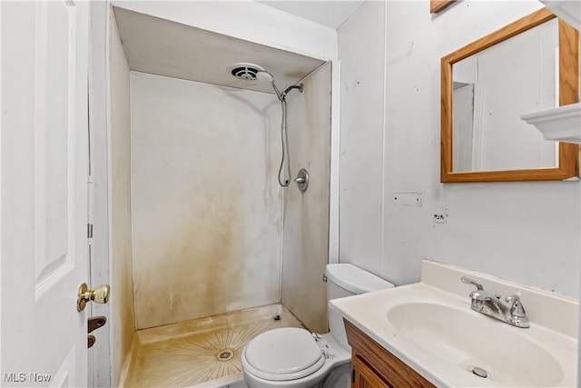 bathroom featuring vanity, a shower stall, and toilet