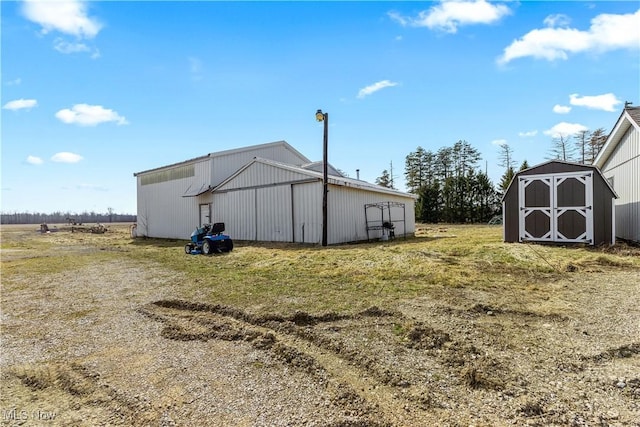 view of yard featuring an outbuilding, a storage unit, and a pole building