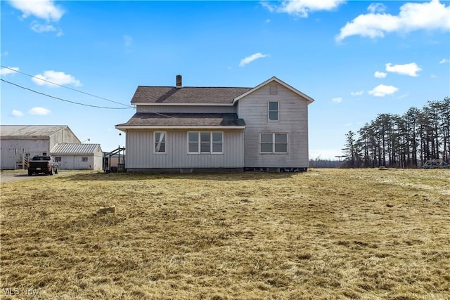 back of property with roof with shingles and a chimney