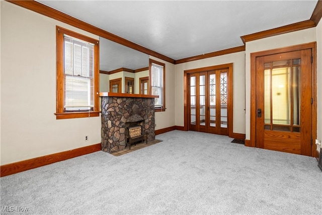 living area featuring baseboards, a healthy amount of sunlight, carpet flooring, and crown molding