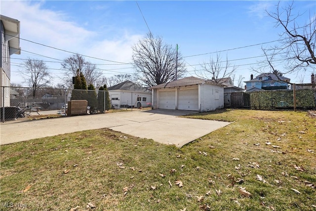 view of yard with an outdoor structure, fence, and a detached garage