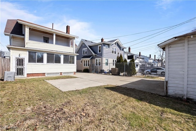 back of house with a yard, a patio, a chimney, and fence