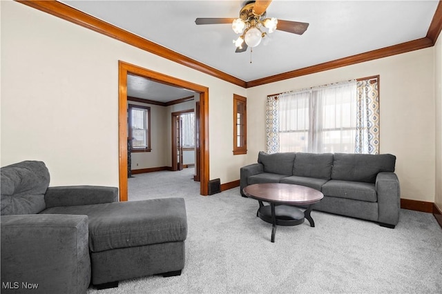 carpeted living room featuring crown molding, a ceiling fan, and baseboards