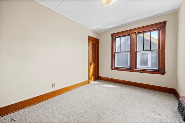 carpeted spare room featuring visible vents and baseboards