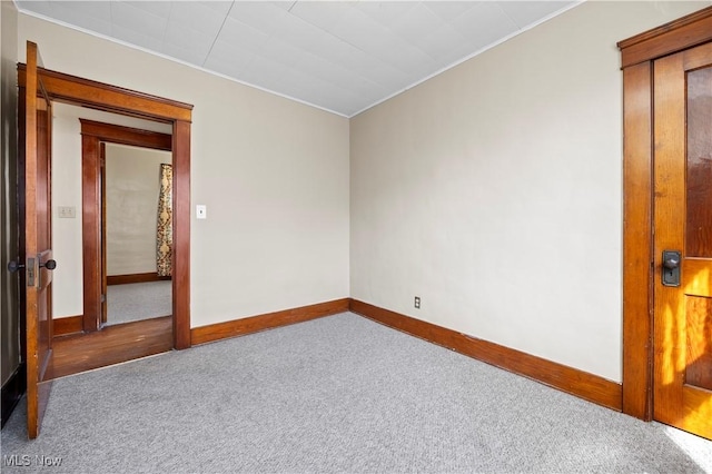 empty room featuring carpet flooring and baseboards