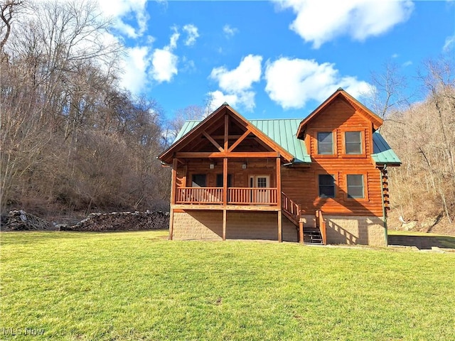 back of house featuring stairway, log exterior, a lawn, metal roof, and a standing seam roof