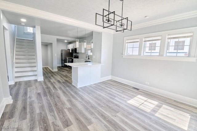 kitchen featuring visible vents, a chandelier, open floor plan, stainless steel appliances, and a sink