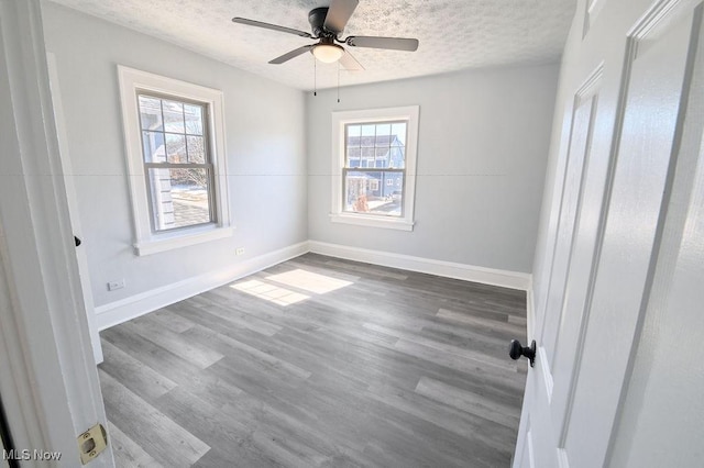 unfurnished bedroom with baseboards, a textured ceiling, wood finished floors, and a ceiling fan