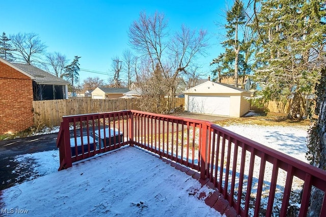 wooden deck featuring an outbuilding, a fenced backyard, a detached garage, and a patio