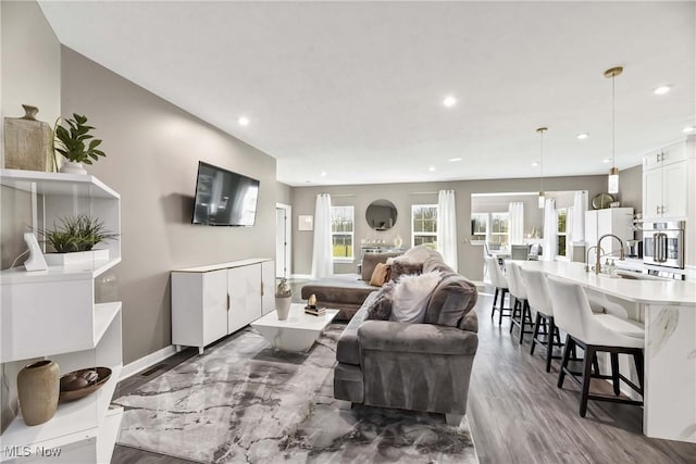 living area with recessed lighting, baseboards, and dark wood-style flooring