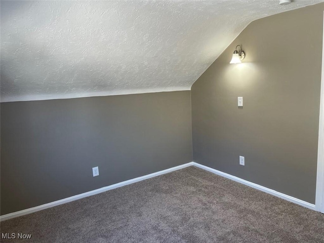 bonus room featuring vaulted ceiling, carpet flooring, baseboards, and a textured ceiling