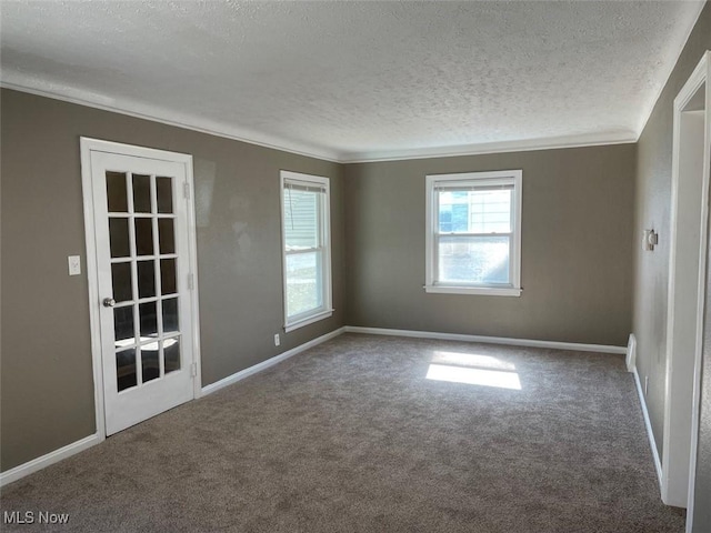 carpeted empty room with a textured ceiling, baseboards, and ornamental molding