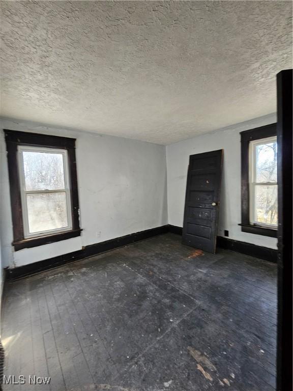 interior space featuring baseboards and a textured ceiling